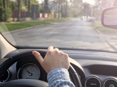 Man driving by looking out the windshield as well as the rear view mirror