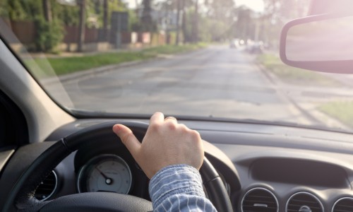 Man driving by looking out the windshield as well as the rear view mirror