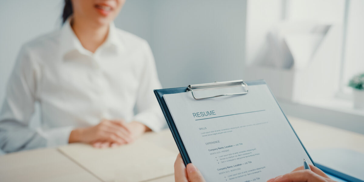 Close up of Asian businesswoman interviewing for a job while discussing the resume at office.
