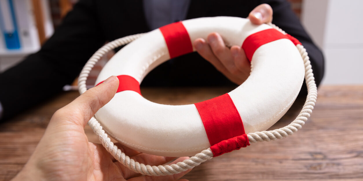 Businesspeople Holding A Lifebuoy In Hands